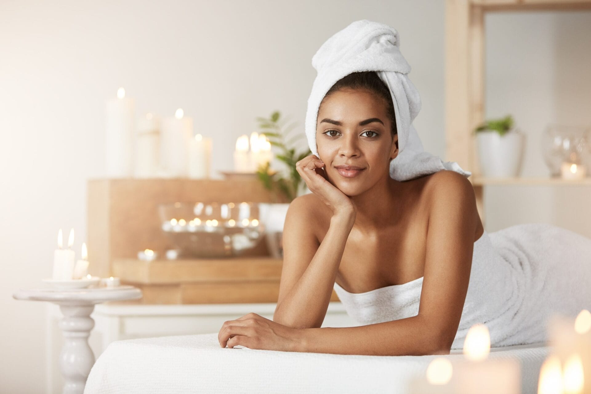 portrait-beautiful-african-woman-with-towel-head-smiling-resting-spa-salon-min